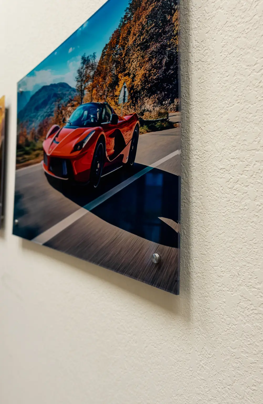 Acrylic print of a red Ferrari floating off the wall on polished standoff mounts