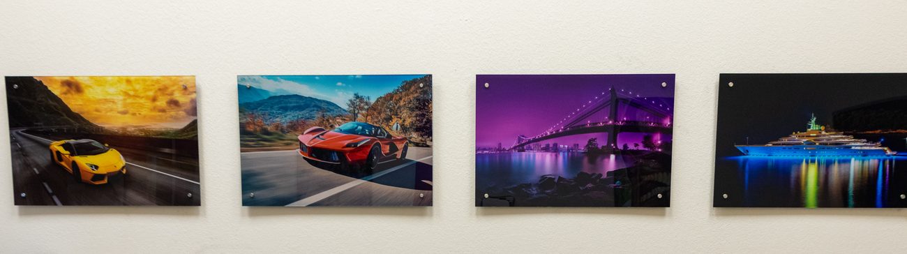 Four car photographs printed and hung in a row